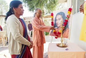 Swami Lalitananda lights the lamp.