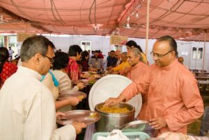 Monks serve prasad after the diksha ceremony.